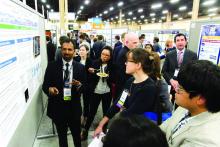 Masih Shinwa, MD, explains his abstract, “Please ‘THINK’ Before You Order: A Multidisciplinary Approach to Decreasing Overutilization of Daily Labs,” to inquiring passersby during Tuesday evening's RIV poster session.