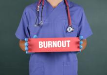 Physician holding burnout sign.
