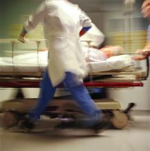 a scene from an emergency dept., with people rushing and a patient on a stretcher