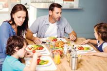 Family gathered around the table with autistic child