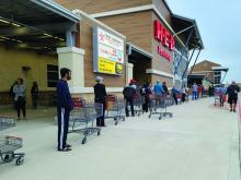 Shoppers wait in a long line outside a grocery store in Houston during the COVID-19 pandemic.