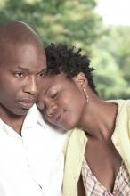 A woman rests her head on her partner's shoulder