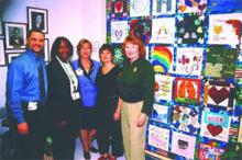 (Left to right) Robert Diaz, RN, Angela Monteque, RN, Kathy Sparger, RN, Harriet Rudoff, and Pamela Pampe show off a quilt created by the staff at South Miami Hospital to communicate what magnet certification means to them. Rudoff was the quiltmaker to translated the design into fabric squares and produced the final quilt.