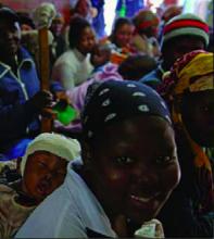 A young mother, sleeping infant tied on her back, waits patiently in the crowded hallway of the Tsepong Clinic for her turn to see the clinic staff for an assessment and HIV test. New patients are taken on a first-come, first-served basis; many of them walk several hours in the pre-dawn darkness from their homes in rural areas to reach the clinic by the time the doors open at 8 a.m.