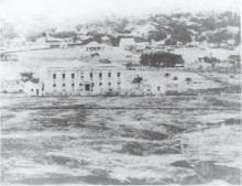 The original Queen's Hospital, shortly after being built, was sparsely surrounded in 1860. Today, the building flanks a bustling downtown Honolulu.