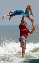 Dr. Maki lifting his partner, Jaci, during a tandem surf competition in Cocoa Beach, Fla.