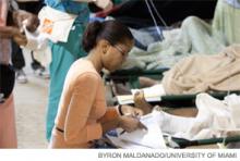 Dr. Luly-Rivera checks the chart of a patient at the tent hospital in Port-au-Prince.