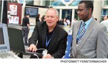 Dave Garland, left, of Seattle-based Simulab Corp., demonstrates a portable ultrasound machine in the HM12 exhibit hall.