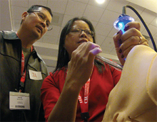 Instructor Sophia Rodgers, ACNP, (right) works with HM15 attendee David Quach during the “Medical Procedures for the Hospitalist” pre-course.