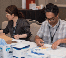 Prabhat Mukerjee, MD, (right) works on his skills during the bedside procedures course. 