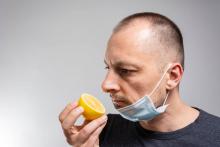 Man with mask smelling a lemon